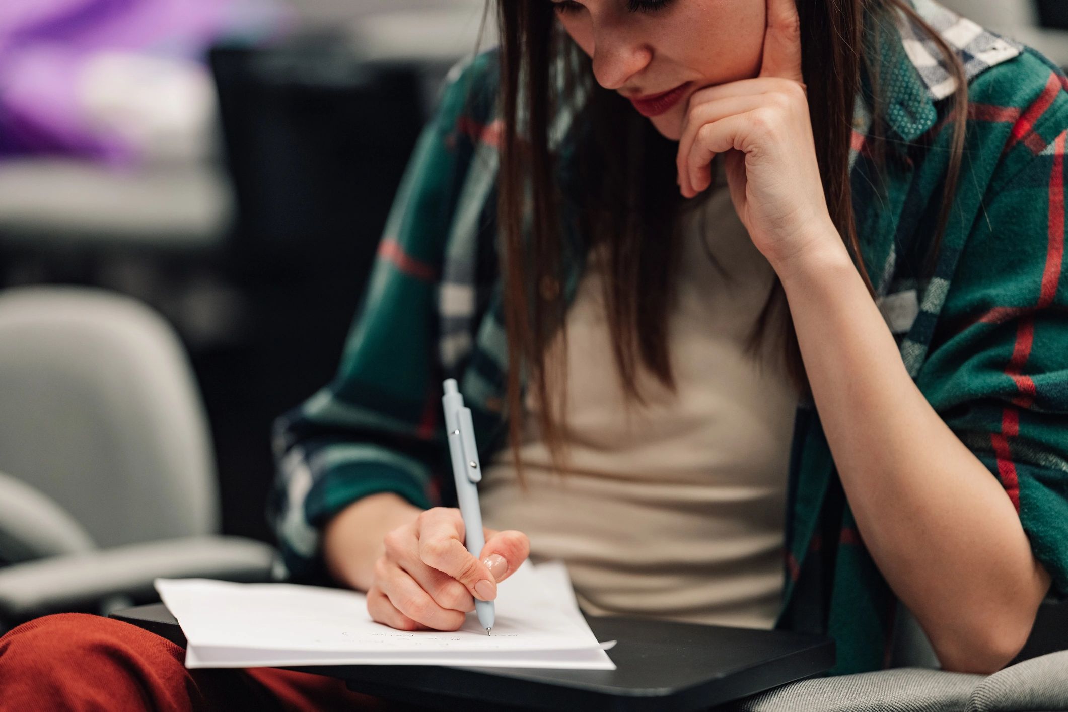 Student writing notes in a notebook